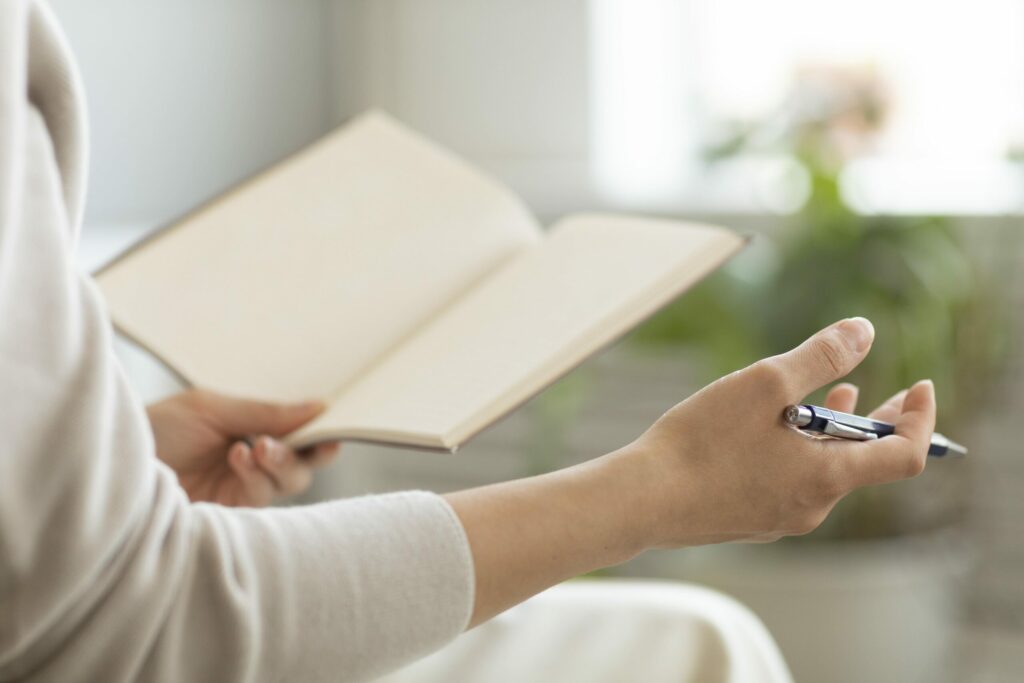 Entretien individuel avec une psychologue du travail : une personne tenant un carnet ouvert et un stylo, dans un cadre calme et bienveillant